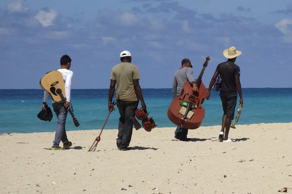 A group of friends who are musicians walking alongside the hidden beach. Used for Hidden Beach Day blog image